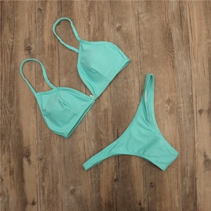 Vue détaillée d'un bikini côtelé vert menthe avec fermoir métallique sur fond de bois