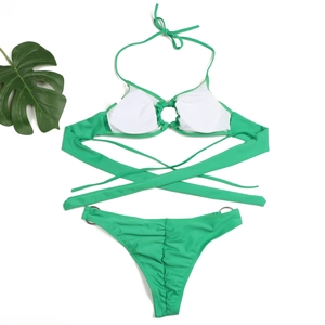 Flat lay of green bikini set with metal rings, removable padding and palm leaf accents