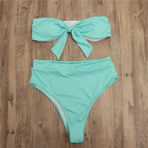 Bikini côtelé vert menthe avec grand nœud sur fond en bois, vue à plat de l'ensemble