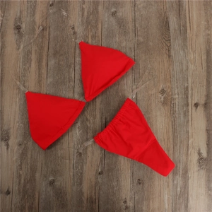 Flat lay of red bikini set featuring clear transparent straps on dark wood background