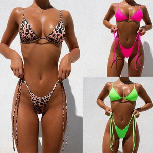 Detailed view of leopard print and neon pink and green string bikini set textures