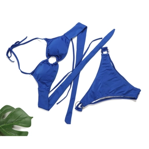 Detail view of sapphire blue bikini with metallic rings on a white background