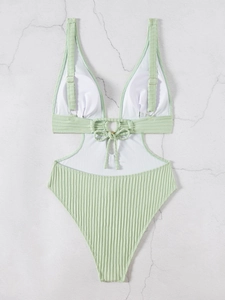 Detailed view of mint green ribbed swimsuit with waist cut-outs and metal ring accent