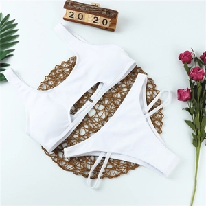 Flachbild eines weißen gerippten Bikinis mit Cut-Out-Detail auf runder Webmatte