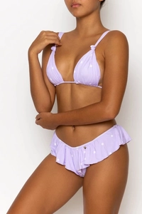 Detailansicht eines lila gepunkteten Bikinis mit Rüschensaum und goldenem Herzanhänger