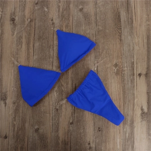 Close-up of royal blue bikini set featuring clear transparent straps on wood background