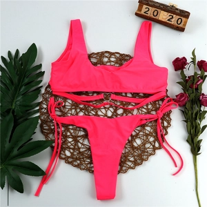 Detailed view of neon pink bikini with heart-shaped metal buckle and side tie straps