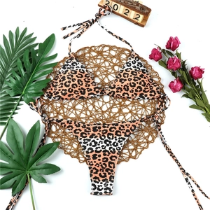 Flat lay of leopard print bikini with halter top and side-tie bottoms on a vacation mat