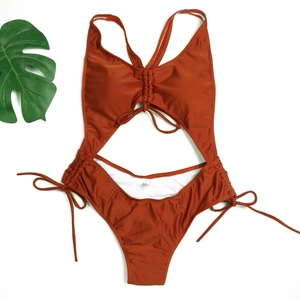 Détail à plat d'un monokini orange brûlé avec cordons latéraux et découpes frontales
