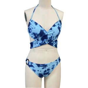 Detail van blauwe tie-dye bikini met overslagontwerp en decoratieve metalen ring aan zijde