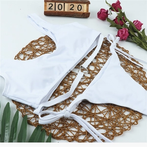 Detail view of white one-shoulder bikini featuring a heart-shaped metal ring on the top