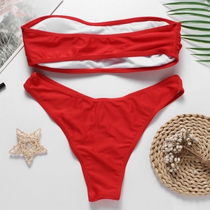 Ensemble bikini bandeau rouge avec doublure blanche présenté sur un fond de vacances