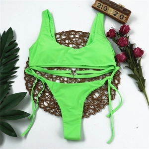 Detail of neon green bikini top with metal heart buckle and cross strap design