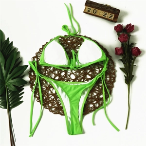 Flat lay of neon green two-piece bikini set with tie-side bottoms on a summer background