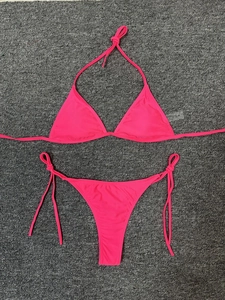 Detailed flat lay of hot pink halter neck bikini with side-tie thong and size M tag