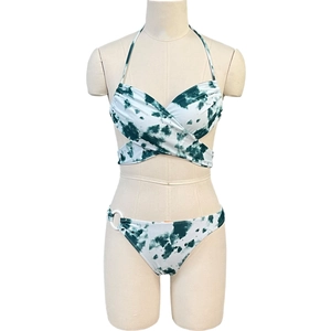 Groen-witte bikini met marmerprint, haltertop en decoratieve ringen aan de zijkant