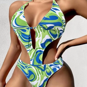 Macro view of monokini showing abstract green print and side cutout design details