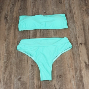 Flat lay of mint green two-piece bikini with bandeau top and high-waisted bottoms