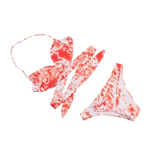 Detail van rood-witte tie-dye bikini met lange wikkelsnoeren en metalen ringen aan de zijkant