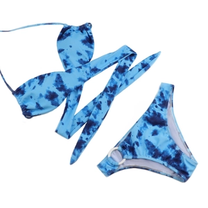 Detailopname van blauwe tie-dye bikini met wikkelbandjes en decoratieve zijring