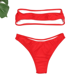 Bikini bandeau rouge vif avec détail ajouré et culotte échancrée à plat sur fond blanc