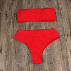 Detailed flat lay of a red bandeau high-waisted bikini set on a wooden background