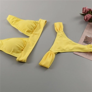 Detailed flat lay of bright yellow two-piece bikini with ruched texture and top padding