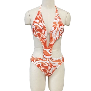 Detailed view of the orange and white swirl pattern on this cutout halter swimsuit