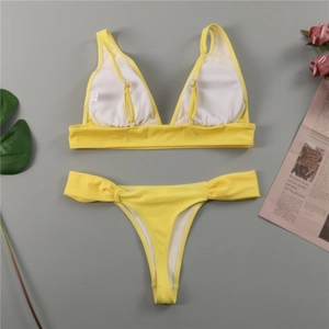 Close-up of yellow bikini fabric showing the 82% polyamide material and removable padding