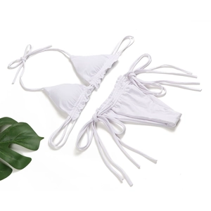 Flach liegendes weißes geripptes Bikini-Set mit seitlich gebundener Hose und Blattdekor