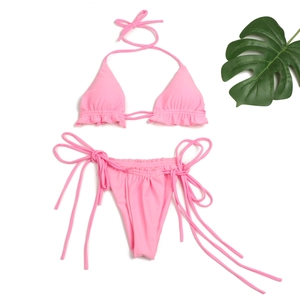 Detailaufnahme des rosa Bikini-Sets mit Rüschen, Neckholder-Top und seitlichen Bändern