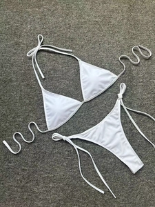 Flat lay of a white two-piece triangle bikini with adjustable side-tie swim bottoms