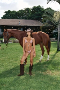 Photo lifestyle d'un bikini rayé rouge et blanc avec chapeau de cowboy et cheval