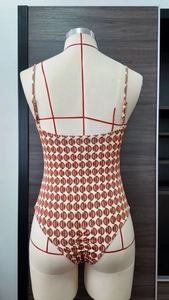Dettaglio del retro di un costume intero con fibbie in metallo e stampa geometrica