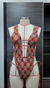 Detail of red bohemian mandala print swimsuit with side ties and deep V neckline