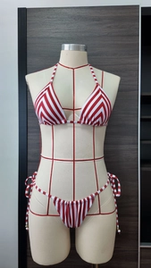 Détail d'un haut de bikini à rayures rouges et blanches avec liens sur un mannequin de mode