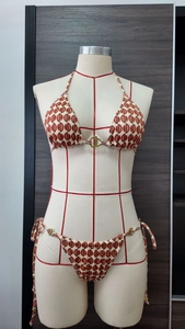 Detail view of abstract geometric print on two-piece bikini with gold metal buckles