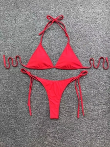 Detailed flat lay of red two-piece bikini set with halter top and side-tie bottoms