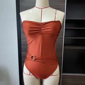 Detail of ruched chest design and silver buckle on reddish-brown one-piece swimsuit