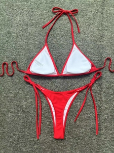 Detail view of red two-piece bikini featuring adjustable side ties and removable pads