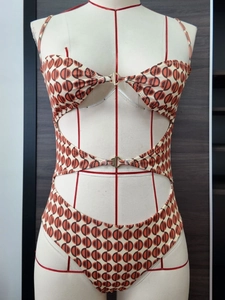 Costume intero con ritagli e stampa geometrica decorato con fibbie in metallo dorato