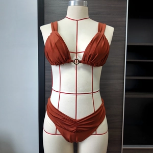 Détail du haut de bikini rouge rouille avec bonnets plissés et anneau en métal argenté