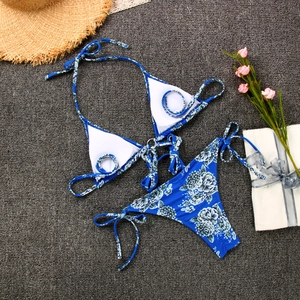 Detail view of blue floral bikini set with three-ring tie design on flat lay background