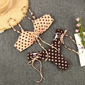 Vue à plat d'un bikini à pois deux pièces avec culotte à nouer et accessoires d'été