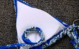 Detail view of floral bikini lining with removable white pads and size M labels