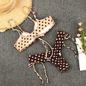 Mise à plat de bikini à pois avec chapeau de paille et fleurs pour les vacances