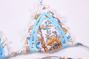 Détail d'un haut de bikini floral avec bordure en dentelle blanche et liseré bleu