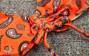 Gros plan du haut de bikini orange à imprimé cachemire avec cordon serrage