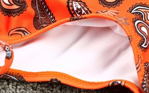 Détail du tissu de maillot de bain imprimé cachemire orange avec doublure blanche