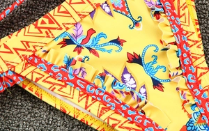 Detail of yellow bikini bottom featuring ethnic print and ruffled frill textures